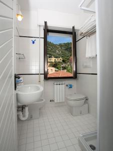 a bathroom with a sink and a toilet and a window at Residence Le Dune Club in Varigotti