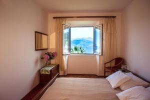 a bedroom with a bed and a large window at Pansion Tereza in Lopud Island
