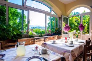 une salle à manger avec des tables et de grandes fenêtres dans l'établissement Pansion Tereza, à Lopud