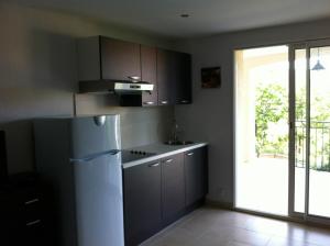 een keuken met een koelkast en een glazen schuifdeur bij Mas des Grives in Bauduen