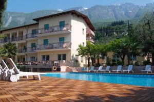 a resort with a swimming pool and a building at Hotel Casa Serena in Malcesine