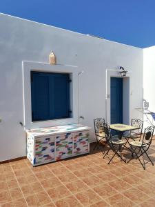 sala de estar con mesa, sillas y TV en Il Canto delle Cicale, en Agia Marina