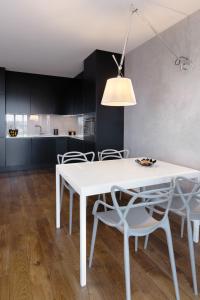 Apartament Towarowa 37 في بوزنان: طاولة طعام بيضاء وكراسي في مطبخ