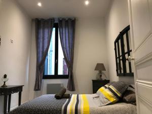 un dormitorio con una cama y una ventana en Les Chambres du Palais, en Carcassonne
