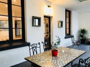 a table and chairs in a room with windows at Les Chambres du Palais in Carcassonne