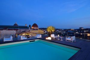 una piscina en la azotea de un edificio por la noche en Hotel Glance In Florence, en Florencia