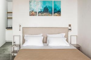 a bed with white pillows and a painting above it at Luxury Villa Artemis by Mykonos Luxury in Elia Beach +34 photos