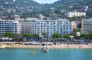 カンヌにあるResidences Fleuries - behind Cannes Croisette Bvdの海上の大きな白い建物