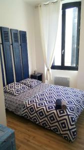 a bedroom with a bed with a blue and white comforter at Les Chambres du Palais in Carcassonne