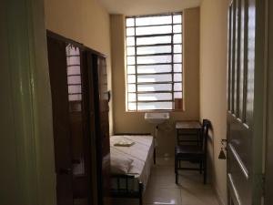 a small room with a bed and a window at Hotel Chaves - Quartos Individuais in Sao Paulo