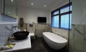 a bathroom with a large bath tub and a sink at Watersmeet Hotel in Woolacombe