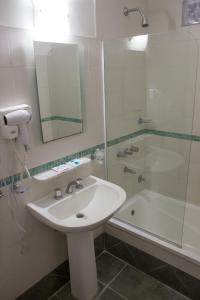 uma casa de banho com um lavatório, um chuveiro e uma banheira em Hotel Milton em La Paz