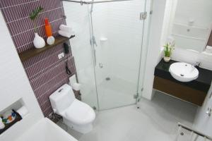 
a bathroom with a toilet, sink, and shower at Pattaya Discovery Beach Hotel - SHA Extra Plus in Pattaya

