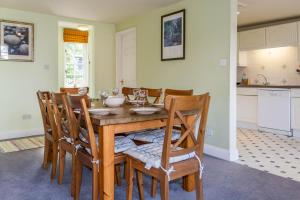 uma sala de jantar com uma mesa de madeira e cadeiras em 4 Bell Lodge, Thorpeness em Thorpeness