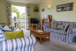 a living room with two couches and a television at 4 Bell Lodge, Thorpeness in Thorpeness