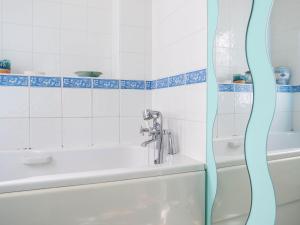 a bathroom with a bath tub and a sink at 4 Bell Lodge, Thorpeness in Thorpeness +9 photos