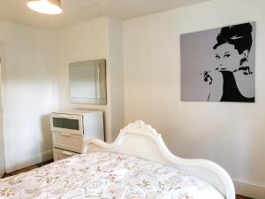 マンチェスターにある504 Wilmslow Roadのベッドルーム1室(ベッド1台付)が備わります。壁には絵画が飾られています。