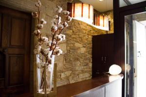 a vase filled with white flowers sitting on a counter at Hotel A Tafona do Peregrino in Santiago de Compostela