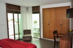 a bedroom with a bed and a room with a balcony at Dakhla Sur Mer Hôtel in Dakhla