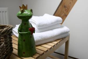a frog with a crown sitting on a table with towels at Pension Kerckenhof in Xanten +20 photos
