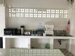 a kitchen counter with a sink and a microwave at Baan Ploy In in Chiang Mai