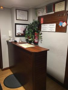 a reception desk in a office with a plant at Hostal Hilton in Burgos