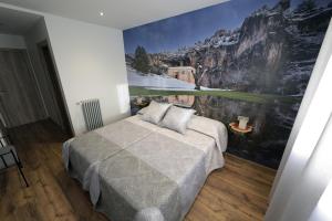 a bedroom with a large painting on the wall at Casa Rural La Puerta Del Río Lobos in San Leonardo de Yagüe