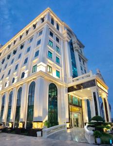 Un grand bâtiment blanc avec de nombreuses fenêtres dans l'établissement Golden Palace Hotel, à Hai Phong