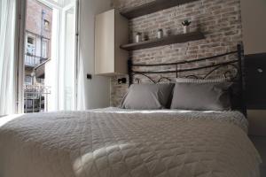 una camera con un grande letto con un muro di mattoni di Al Mattina Apartments Belgrade a Belgrado