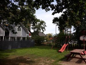 un patio con parque infantil, mesa y columpio en Pobierowo Bracka en Pobierowo