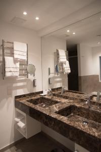 a bathroom with a large sink and a large mirror at Hotel absolute in Gernsheim