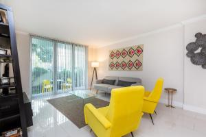 a living room with yellow chairs and a couch at Tides Miami 2BR Condo on the beach in Hollywood