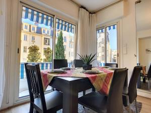 a dining room with a table and chairs and a large window at Nestor&Jeeves - L'OLYMPIC - Central - Very close sea in Nice