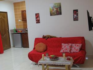 a red couch in a living room with a table at Apartments 1000 and 1 night RedSeaLine in Hurghada