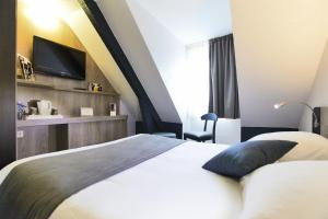 a hotel room with a bed and a tv at Kyriad Hotel Nevers Centre in Nevers +45 photos