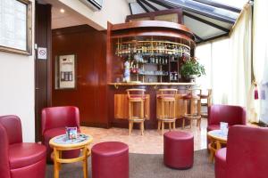 a bar in a restaurant with red chairs and tables at Kyriad Hotel Nevers Centre in Nevers