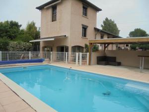 a large swimming pool in front of a house at Gites de Frans in Frans