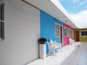 un edificio de colores vivos con un banco en un porche en Inmobiliaria Percales en Veracruz