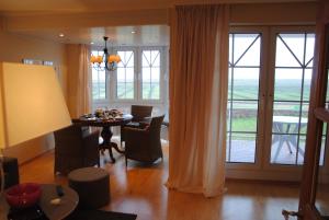 a dining room with a table and chairs and a large window at Inselresidenz Wattenmeer - Wohnung 7 in Juist