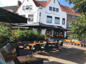 Una donna seduta a un tavolo di fronte a un palazzo di cafe 't Vonderke a Eindhoven