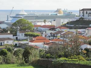 ein Kreuzfahrtschiff im Ozean neben einer Stadt in der Unterkunft Casa Arrudas in Ponta Delgada