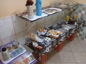 a kitchen with two shelves filled with different types of food at Pousada Alto Riviera in Macaé