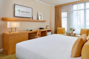 Een bed of bedden in een kamer bij Orchard Garden Hotel