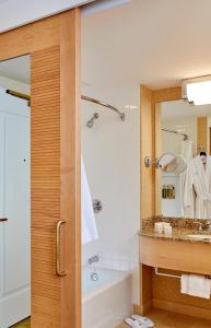
a bathroom with a shower, sink, and mirror at Orchard Garden Hotel in San Francisco
