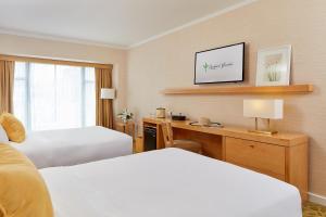 Postel nebo postele na pokoji v ubytování Orchard Garden Hotel