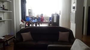 un sofá de cuero en una sala de estar con ventana en Casa Puerto Ayora, en Puerto Ayora