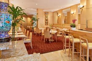 a restaurant with tables and chairs and a vase at Orchard Garden Hotel in San Francisco