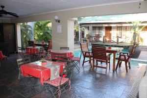 a restaurant with tables and chairs and a pool at Royal Game Guest House in Phalaborwa