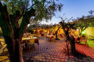 洛特佐拉伊的住宿－里齊爾尼露營鄉村酒店，庭院配有桌椅和一棵树