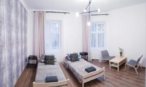 凯尔采Guest Room RÓWNA的有两张床、一张桌子和几把椅子的房间
